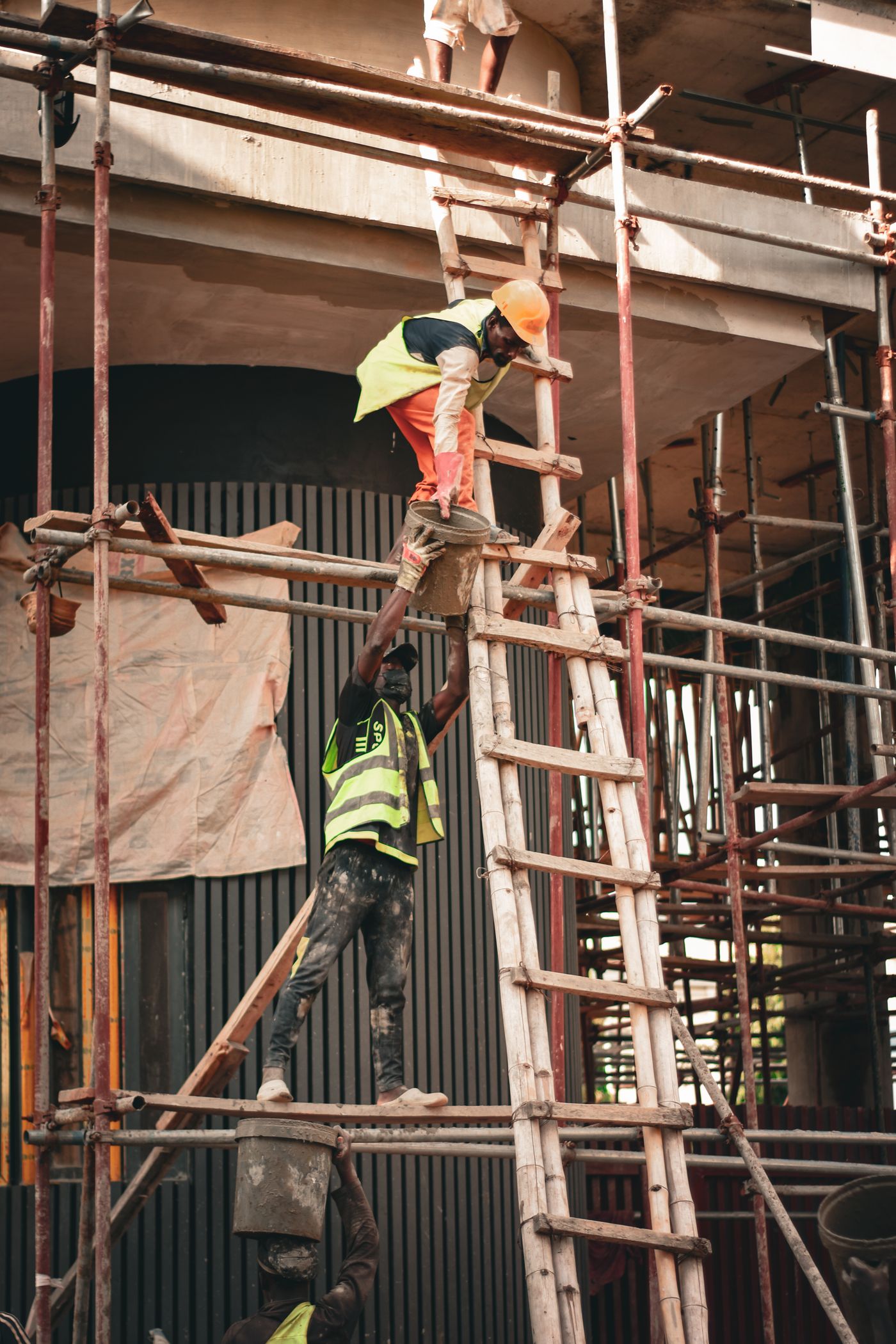 Equipo con cascos trabajando en andamio